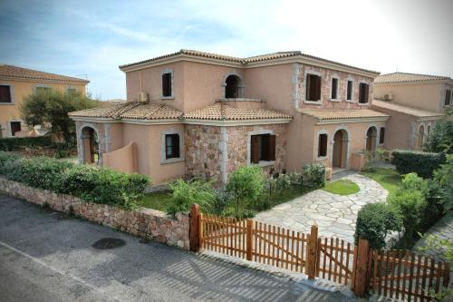 a large house with a fence in front of it at Ville del Mar in San Teodoro
