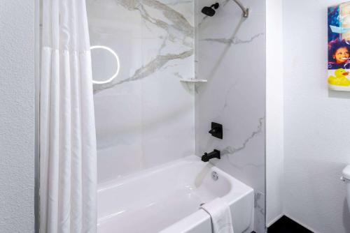 a white bath tub with a shower curtain in a bathroom at La Quinta Inn & Suites by Wyndham Maricopa Copper Sky in Maricopa