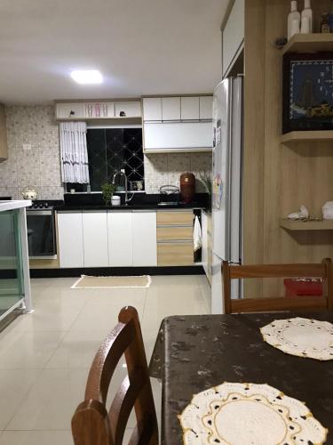 kuchnia ze stołem i lodówką w obiekcie Residencial Jardim Curitiba w mieście Kurytyba