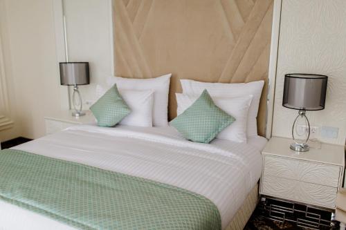 a bedroom with a bed with two night stands and two lamps at Muller Hotel Boutique & Spa in Galaţi
