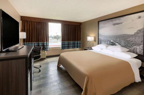 a hotel room with a large bed and a flat screen tv at Super 8 by Wyndham Laredo in Laredo