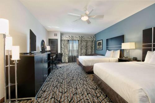 a hotel room with two beds and a ceiling fan at La Quinta Inn & Suites by Wyndham Lubbock Southwest in Lubbock