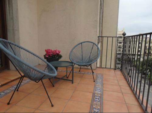 two chairs and a table on a balcony at Ático dos dormitorios en el centro de Córdoba in Córdoba