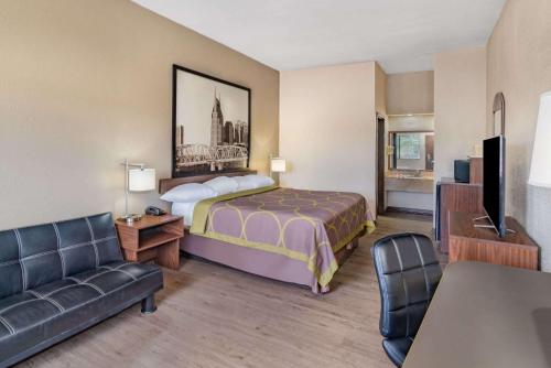 a hotel room with a bed and a couch at Super 8 by Wyndham Columbia in Columbia