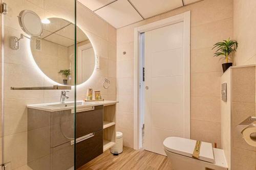 y baño con aseo, lavabo y espejo. en 797 Holiday Rentals - Benalbeach- Moderno piso para 5 con vistas al mar, en Benalmádena