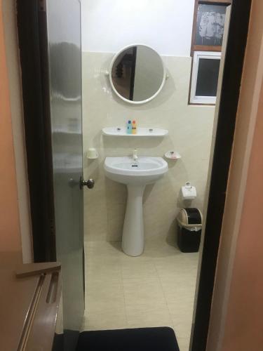 a bathroom with a white sink and a mirror at Unawatuna Beach Bungalow - in Unawatuna
