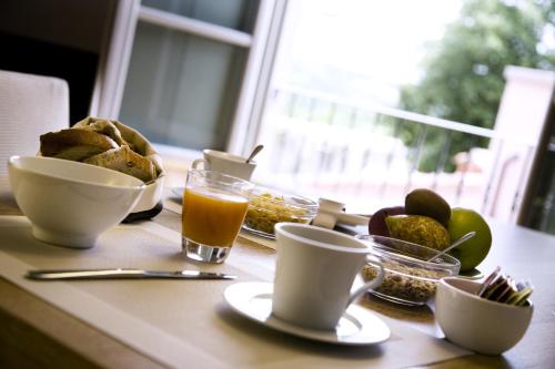 - une table avec petit-déjeuner composé de pain et de tasses de café dans l'établissement Villa Il Palagio, à Rignano sullʼArno