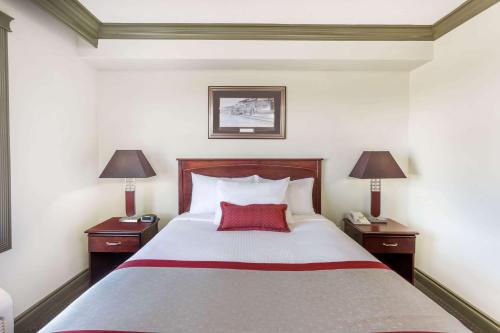 a hotel room with a large bed with two lamps at Ramada by Wyndham Hinton in Hinton