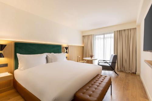 a hotel room with a large bed and a chair at Best Western Plus Casablanca City Center in Casablanca