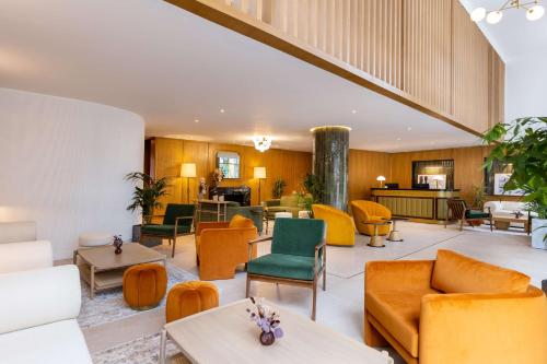 a lobby with orange and green chairs and tables at Best Western Plus Casablanca City Center in Casablanca