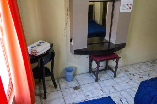 a bathroom with a vanity and a mirror and a stool at OYO Hotel Colón, Plaza Bicentenario, Zacatecas Centro in Zacatecas