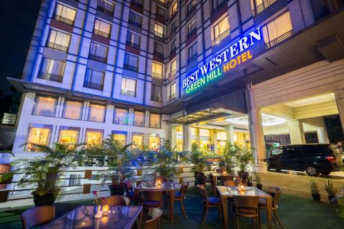 a hotel with tables and chairs in front of a building at Best Western Green Hill Hotel in Yangon