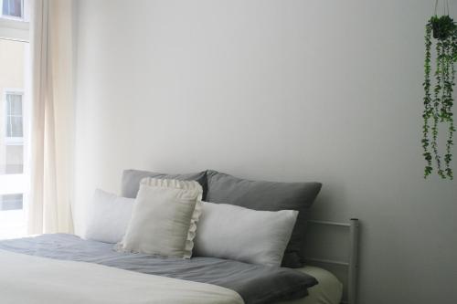 a bed with white pillows sitting next to a window at American Ease Apartments - Hahnbach, Vilseck, Weiden in Hahnbach