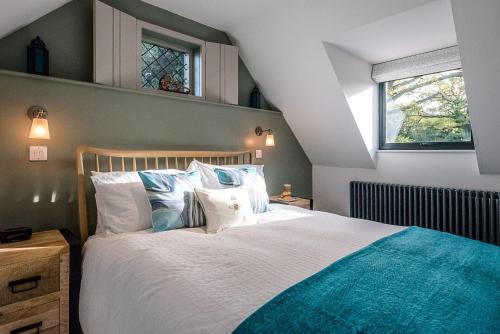 a bedroom with a large bed with blue and white pillows at Little Honey Pot in Saxmundham