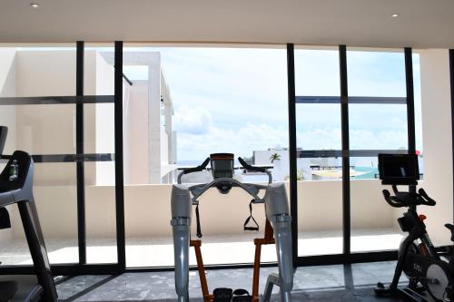 a gym with a view of a balcony with two exercise bikes at Ceren Luxury Apartments at Fifth Avenue by Spot Rentals in Playa del Carmen