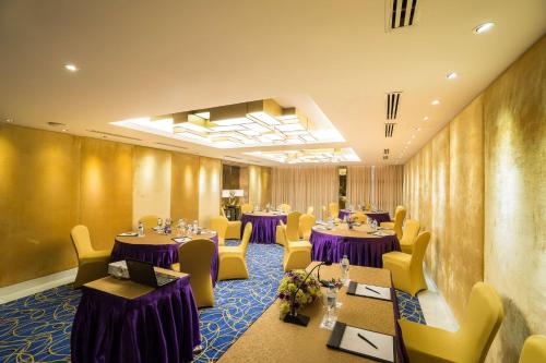 a restaurant with purple tables and yellow chairs at Best Western Chinatown Hotel in Yangon