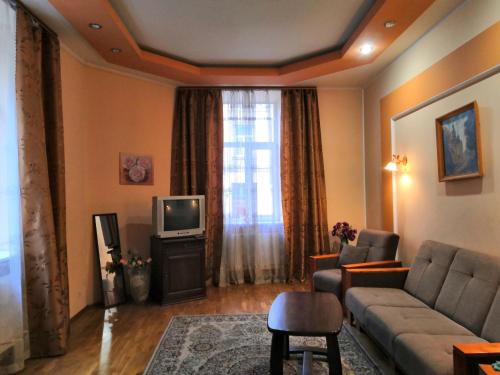 sala de estar con sofá y TV en Apartament-Minihotel Elpida, en Leópolis