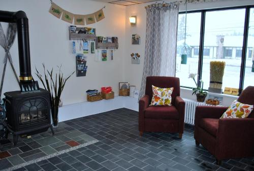 a living room with two chairs and a stove at Gauthier's Saranac Lake Inn in Saranac Lake