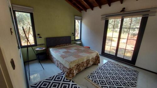 a bedroom with a bed and two large windows at Villa olive junior in Ula