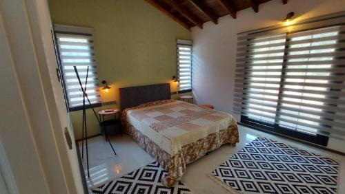a bedroom with a bed in a room with windows at Villa olive junior in Ula