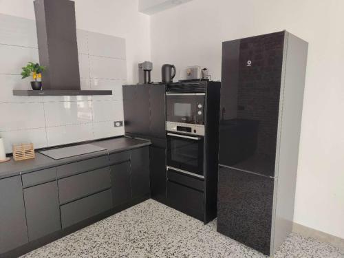 a kitchen with a black refrigerator and a stove at Casa de los Mendoza - Casa Solariega en el casco histórico in Alcalá de Henares