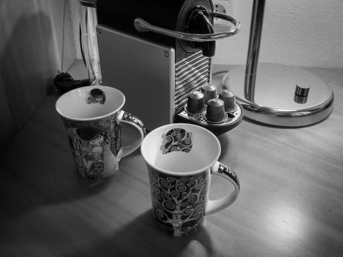 two coffee mugs sitting on a table next to a mirror at Landhaus zu Kürenberg in Bergham
