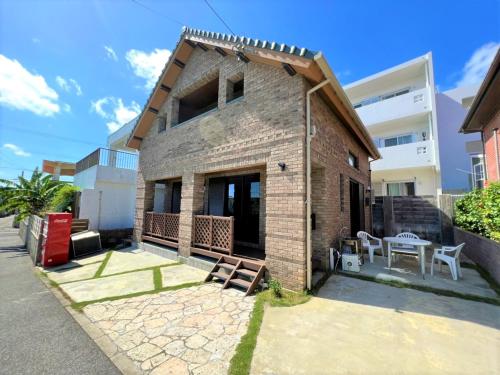 Cette maison en briques dispose d'une terrasse et d'une table. dans l'établissement HONRENGA石垣島, à Ishigaki