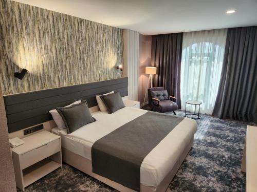 チョルルにあるYeşilyurt Park Otelの大きなベッドと椅子が備わるホテルルームです。