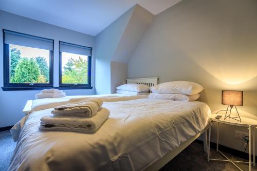 a bedroom with a large bed with towels on it at Opulent, relaxing home with Hot Tub in Fochabers