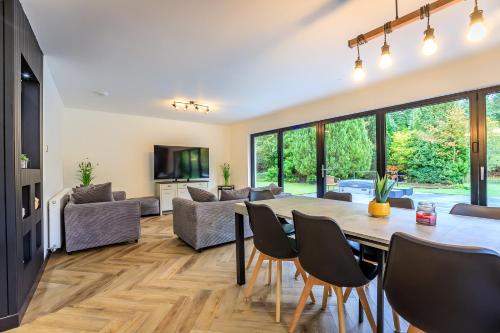 a living room with a table and chairs at Opulent, relaxing home with Hot Tub in Fochabers
