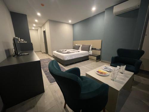 una camera d'albergo con letto, tavolo e sedie di AGORA ROYAL HOTEL a Esenyurt