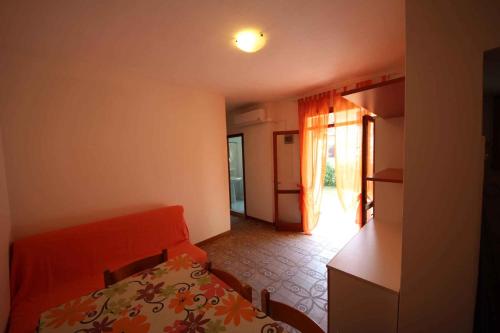 ロゾリーナ・マーレにあるApartments in Rosolina Mare 24851のベッドとキッチン付きの小さな部屋