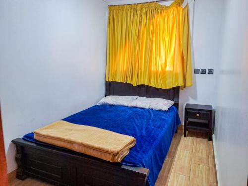 a bedroom with a bed with a yellow curtain at Apartamentos EL BARCO in Sidi Ifni