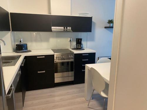 uma cozinha com electrodomésticos a preto e branco e uma mesa em Style 1BR with sauna,Tornio city em Tornio