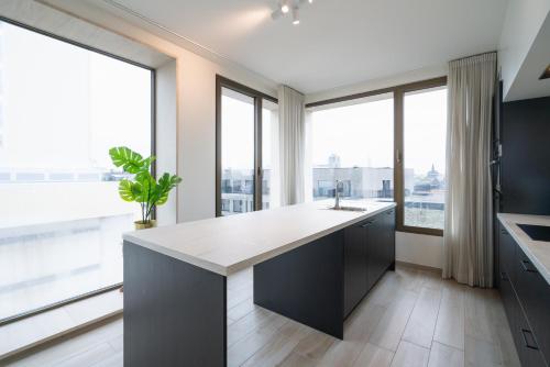a kitchen with large windows and a large kitchen island at Opera Square Apartments in the Center of Antwerp in Antwerp