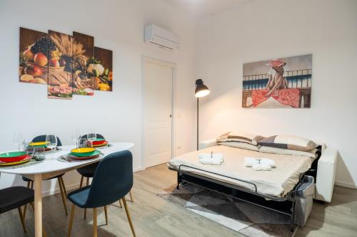 a bedroom with a bed and a table and a dining room at Nord Milano Luxury Apartments in Bresso