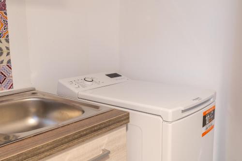 een keuken met een wastafel en een wasmachine bij Nord Milano Luxury Apartments in Bresso
