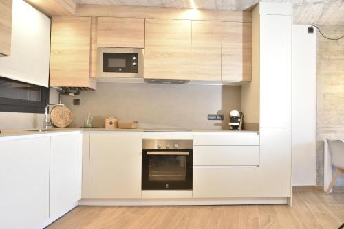 a kitchen with white cabinets and a stove at ELS 4 PICS in Puigcerdà