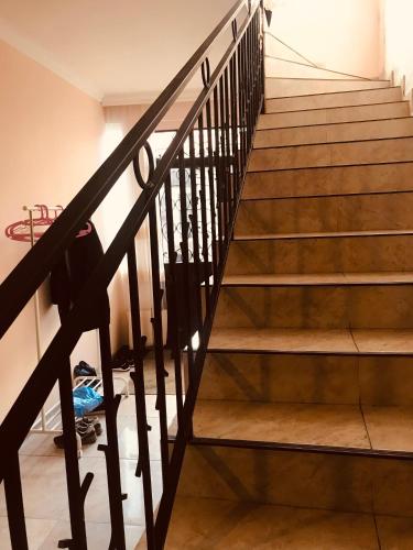 a stairwell in a house with wooden stairs at Sweethome in Batumi