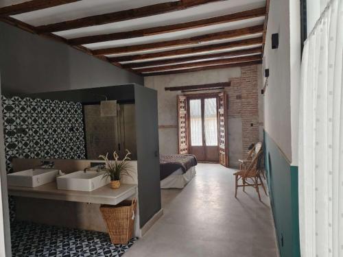 a bathroom with two sinks and a bed in a room at Casa de los Mendoza - Casa Solariega en el casco histórico in Alcalá de Henares