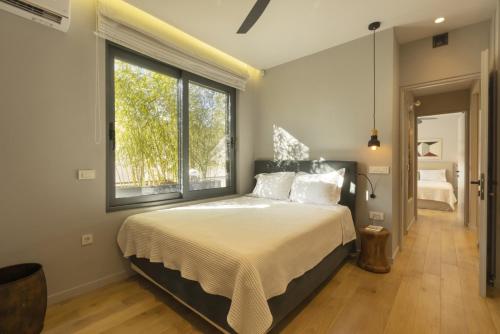 una camera con un letto e una grande finestra di Elegant, Chic, Hip 2 BR w/ forest view in Athens! ad Atene