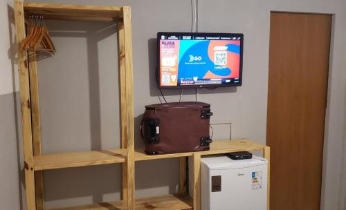 a television sitting on a shelf with a suitcase at CASA MAR DE FORA in Fernando de Noronha