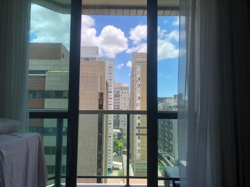 una finestra con vista sullo skyline della città di Apart Hotel Volpi a Belo Horizonte