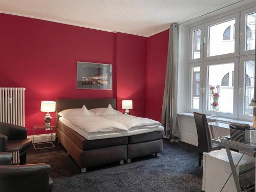 a bedroom with a bed and a red wall at Hotel Wagner im Dammtorpalais in Hamburg