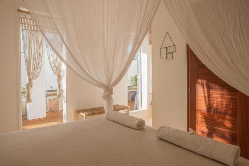 a bedroom with a bed with curtains and a window at La Kazaka Terre Sainte in Saint-Pierre
