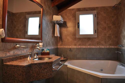y baño con bañera y lavamanos. en Rincon del Valle en Merlo