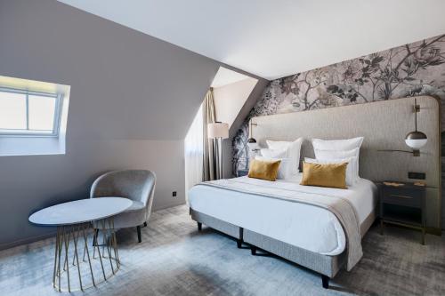 a hotel room with a bed and a table at Fleur de Loire in Blois