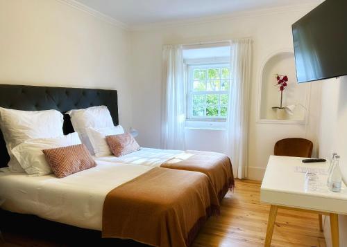 a bedroom with a large bed and a window at Villa Vasco da Gama in Cascais