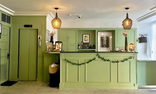 a green kitchen with green cabinets and a counter at Hotel de Berne in Nice