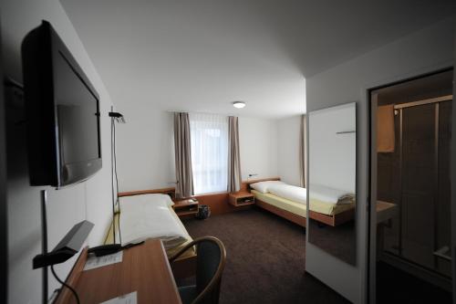 a hotel room with a bed and a tv at Hotel Freihof Swiss Lodge in Unterägeri